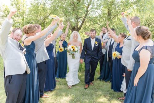 a bride and groom and their wedding party cheering at Cedar Shore Resort in Oacoma