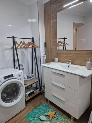 a bathroom with a washing machine and a sink at La Casona in Redondela
