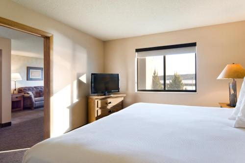 a hotel room with a bed and a television at Cedar Shore Resort in Oacoma