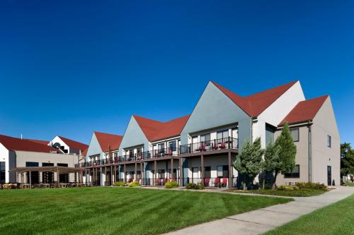 a large building with red roofs on a lawn at Cedar Shore Resort in Oacoma