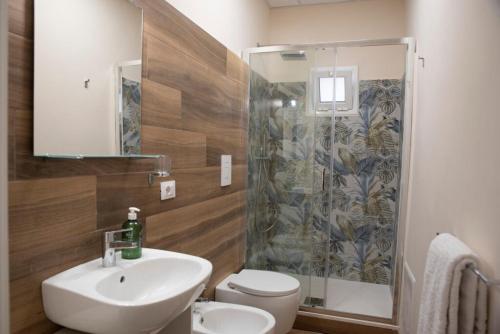Un baño con lavabo, inodoro y ducha. en Akrone Rooms City Center, en Agrigento