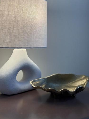 a lamp sitting on a table next to a plate at Scarborough Vacay - 3 bed house in Perth