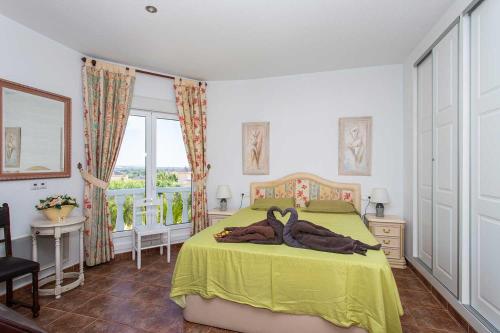 a bedroom with a bed with two penguins laying on it at CH Villa Jupiter La Marquesa in Rojales