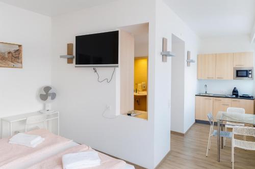a white room with a tv on a wall at Aparthotel Bianca in Vienna in Vienna