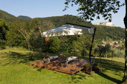 a patio with two chairs under an umbrella at Casa Rivetta in Valmareno