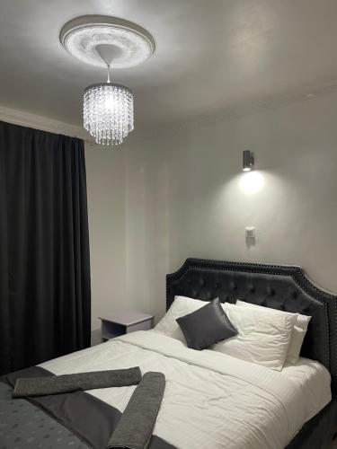 a bedroom with a large white bed with a chandelier at Kels Place ,Runda , Chogoria , Tharaka Nithi, Kenya in Mwangarimwe