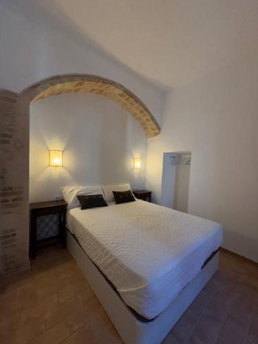 a bedroom with a large white bed with two tables at Sol de Ancha in Carmona