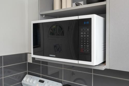 a microwave oven hanging on a wall in a kitchen at Grove Park Motor Lodge in Blenheim