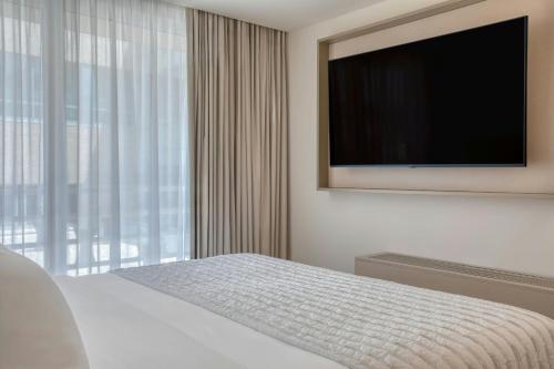 a bedroom with a flat screen tv and a bed at Le Meridien Lav Split in Podstrana
