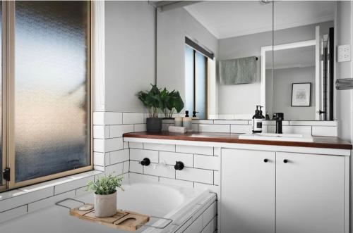 a white bathroom with a tub and a sink at Sunbury on the hill close to airport with wifi pet friendly in Sunbury