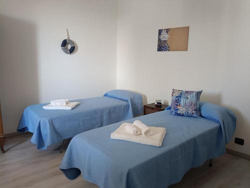 2 Betten in einem Zimmer mit blauer Bettwäsche in der Unterkunft Una Finestra sul mare in Villa San Giovanni
