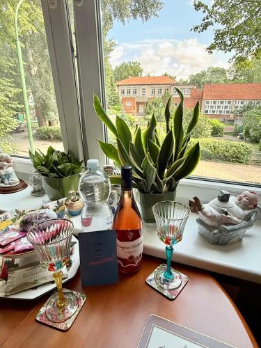 a table with a bottle of alcohol and a window at Central Antique Gallery Apartment self-check in in Klaipėda