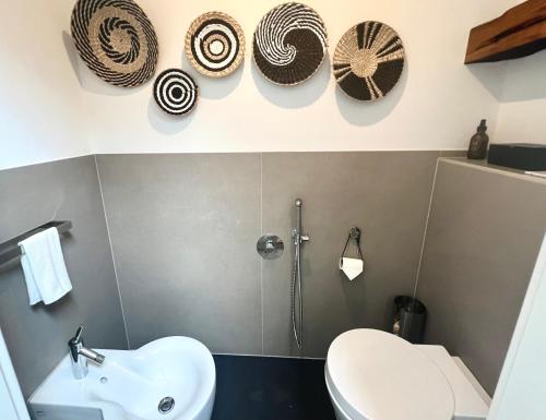 a bathroom with a sink and a toilet and hats at Mosel Winzerhaus an der Lieser - Sonnenterrasse, Weinberge & Nähe Bernkastel-Kues in Maring-Noviand