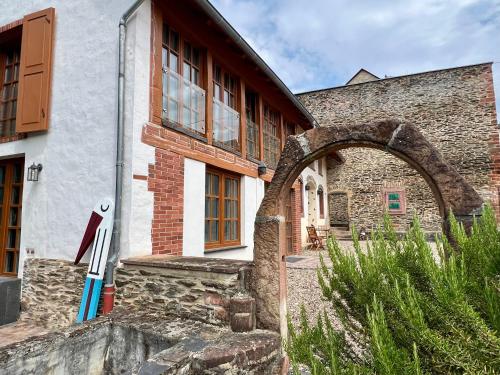 a stone building with an archway in front of it at Mosel Winzerhaus an der Lieser - Sonnenterrasse, Weinberge & Nähe Bernkastel-Kues in Maring-Noviand