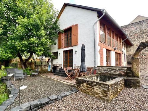 a house with an umbrella in front of it at Mosel Winzerhaus an der Lieser - Sonnenterrasse, Weinberge & Nähe Bernkastel-Kues in Maring-Noviand