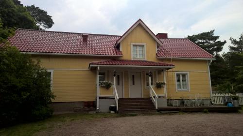 a yellow house with a red roof at Majatalo Martta in Nauvo