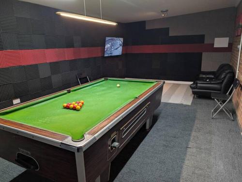 a pool table with balls on top of it in a room at Spacious 3 bedroom house with games room in Kirby Muxloe