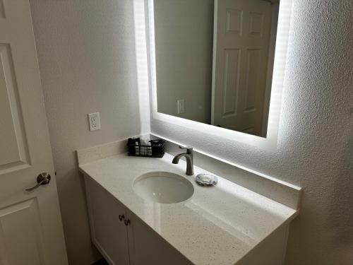 a bathroom with a sink and a mirror at West Beach Suites in Lincoln City