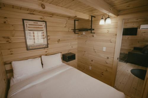 a bedroom with a white bed in a wooden room at Teton Valley Resort in Victor