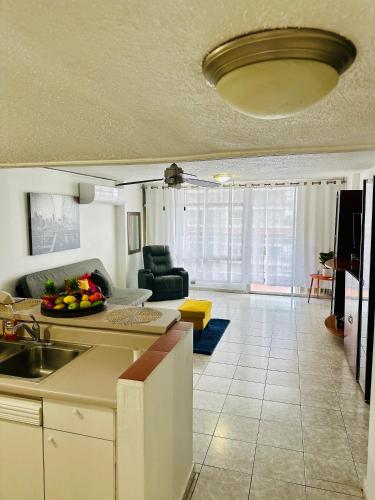 a kitchen and a living room with a couch at Valdez Apartment in San Juan