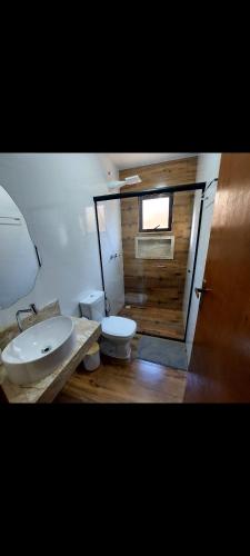 a bathroom with a sink and a toilet at Recanto das palmeiras 2 in São Thomé das Letras