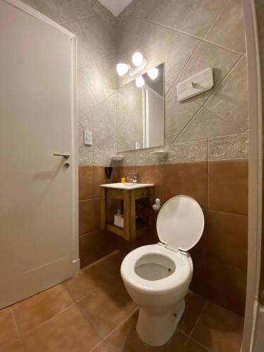 a bathroom with a white toilet and a mirror at Departamento Las Heras in Mar del Plata