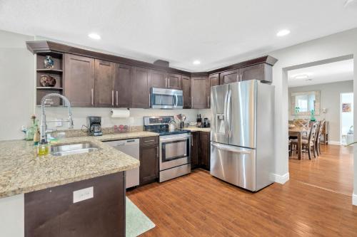 a kitchen with wooden cabinets and a stainless steel refrigerator at Spacious House with big backyard in N. Hyde Park / Close to Downtown in Tampa