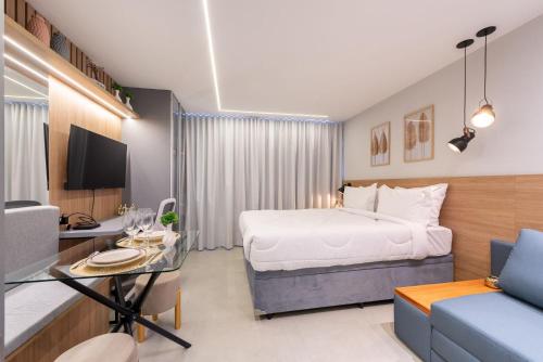a bedroom with a bed and a desk and a couch at GO Rio Branco by LikeHome in Porto Alegre