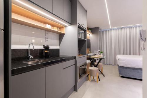 a kitchen with a sink and a bed in a room at GO Rio Branco by LikeHome in Porto Alegre