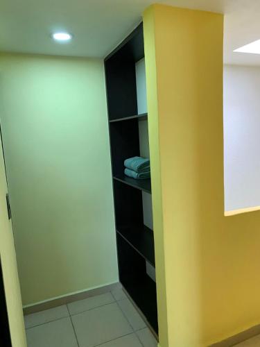 a closet with black shelves and a yellow wall at Hermosa casa residencial alberca propia climatizada in Cuautla Morelos