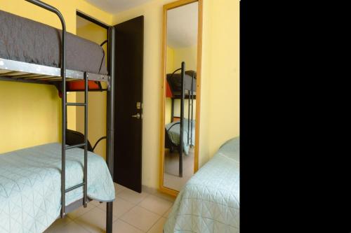 two bunk beds in a room with a mirror at Hermosa casa residencial alberca propia climatizada in Cuautla Morelos