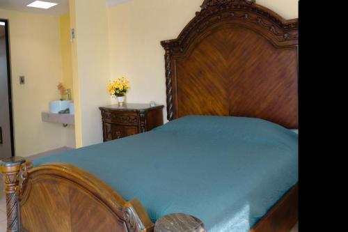 a bedroom with a large wooden bed with blue sheets at Hermosa casa residencial alberca propia climatizada in Cuautla Morelos
