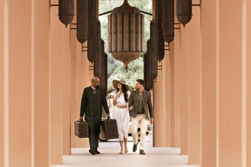 a group of people walking down a corridor at The Ritz-Carlton Ras Al Khaimah, Al Wadi Desert in Ras al Khaimah