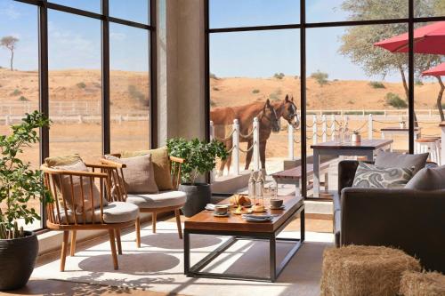 a living room with a horse looking out the window at The Ritz-Carlton Ras Al Khaimah, Al Wadi Desert in Ras al Khaimah