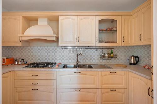 a kitchen with white cabinets and a sink at Luxury Villa Seaview con jacuzzi in Conca dei Marini