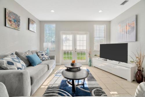 a living room with a couch and a flat screen tv at Spacious House with big backyard in N. Hyde Park / Close to Downtown in Tampa