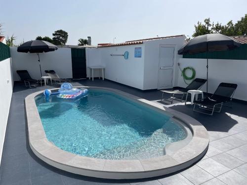 a swimming pool with a inflatable raft in a backyard at Refúgio do Mira in Vila Nova de Milfontes