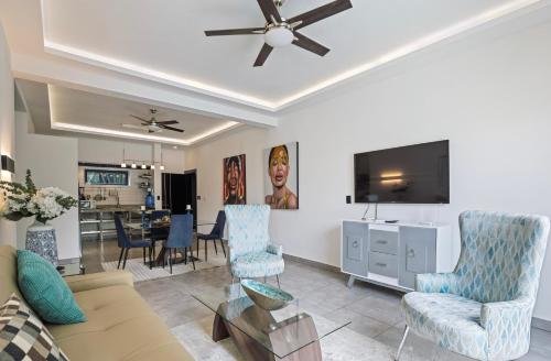 a living room with a couch and a flat screen tv at Instyle Residences at RIZZ SUITES in Sosúa