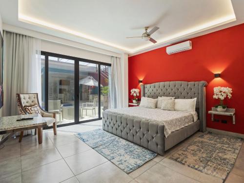 a bedroom with a bed and a red wall at Instyle Residences at RIZZ SUITES in Sosúa