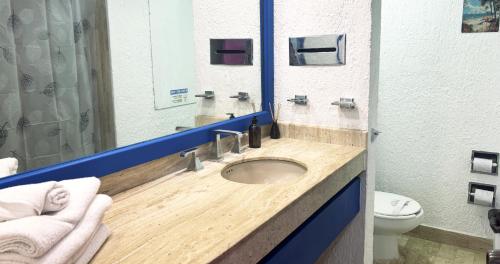 a bathroom with a sink with a mirror and a toilet at Cancun Studio - Steps to Beach and Water Fun in Cancún