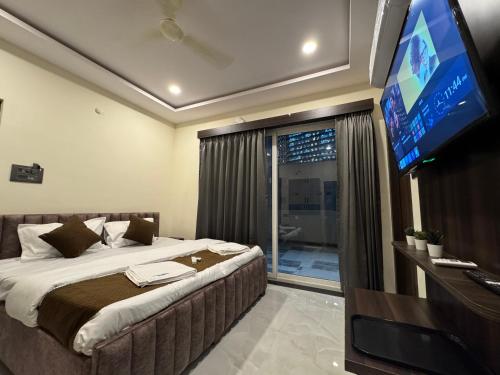 a bedroom with a large bed with a flat screen tv at Hotel Legacy Grand - Rooms & Suites - Near AIG Hospital in Hyderabad
