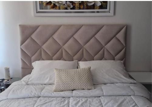a bedroom with a large bed with a large headboard at Trento Class 1001 Elegante y Confortable con Parqueadero in Bucaramanga