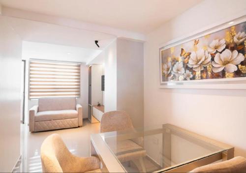 a living room with a glass table and a painting on the wall at Trento Class 1001 Elegante y Confortable con Parqueadero in Bucaramanga