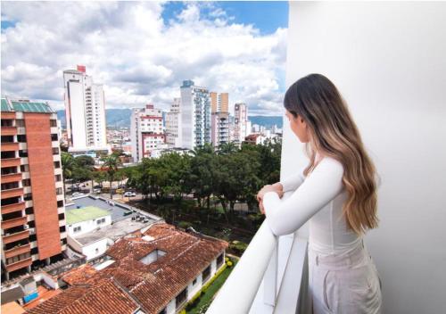 a woman standing on a balcony looking at a city at Trento Class 1001 Elegante y Confortable con Parqueadero in Bucaramanga