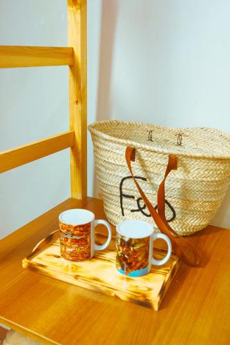 two cups on a tray on a table with a basket at Riad Benyara in Taroudant