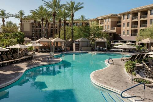 a pool at a resort with chairs and umbrellas at The Westin Kierland Villas, Scottsdale in Scottsdale
