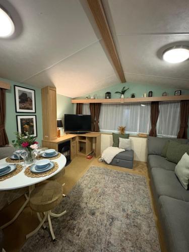 a living room with a couch and a table at Slaley Forest Hexham Caravan Retreat Pet Friendly - sleeps 6 in Slaley