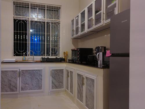 a kitchen with a counter and two windows at Spacious Beachfront Condo -AC - WiFi, Uroa Escape Zanzibar in Uroa