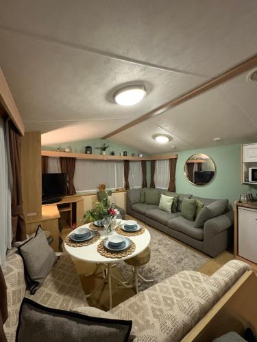 a living room with a couch and a table at Slaley Forest Hexham Caravan Retreat Pet Friendly - sleeps 6 in Slaley