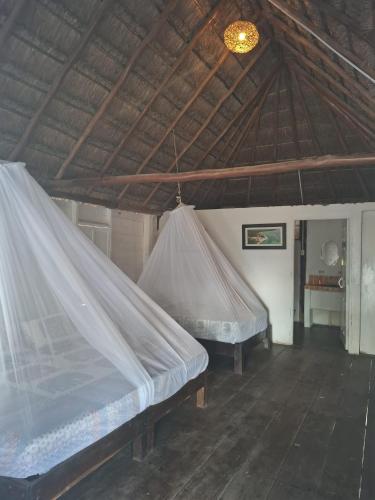 two beds in a room with a roof at Hotel xahuayxol in Mahahual